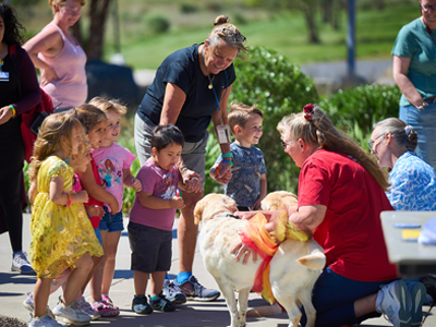 children petting puppies at the monroe campus