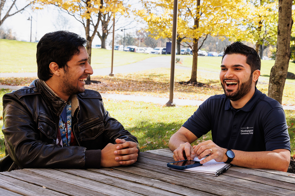 students at table outside on campus