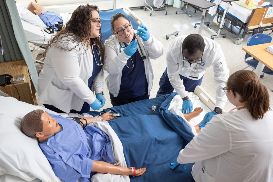 Students working around a practice patient